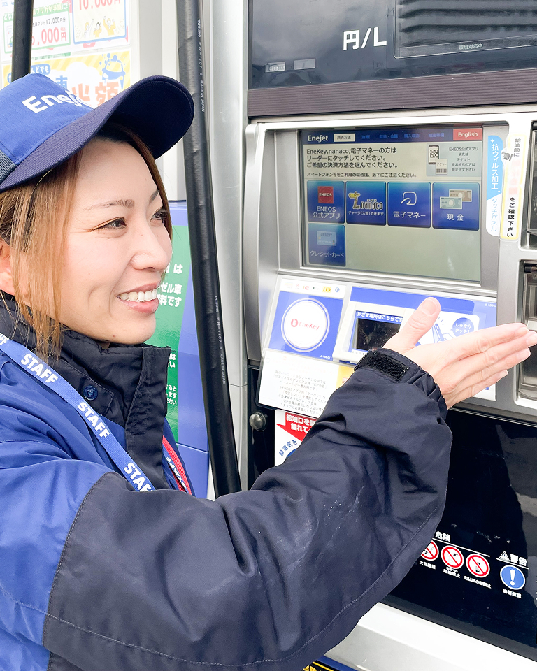 ガソリンスタンドでお客様をご案内するスタッフ
